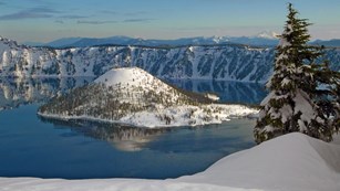 Crater-shaped lake surrounded by snow-capped mountains