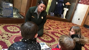Ranger sitting on the floor talking to kids