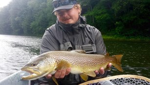 A fishing guide holding a brown trout