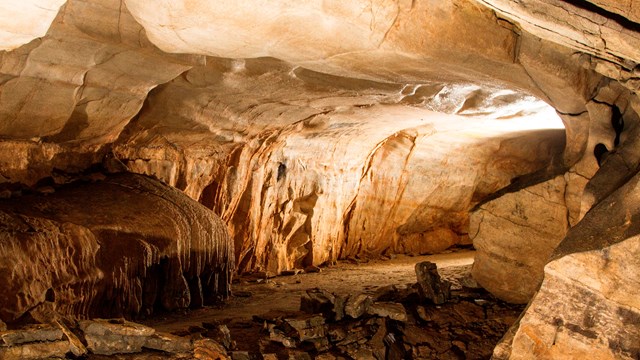 A cave passage with light shining through. 