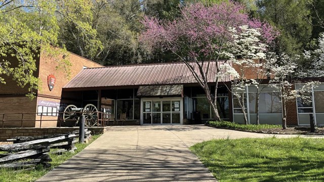 modern building with glass windows surrounded by trees.