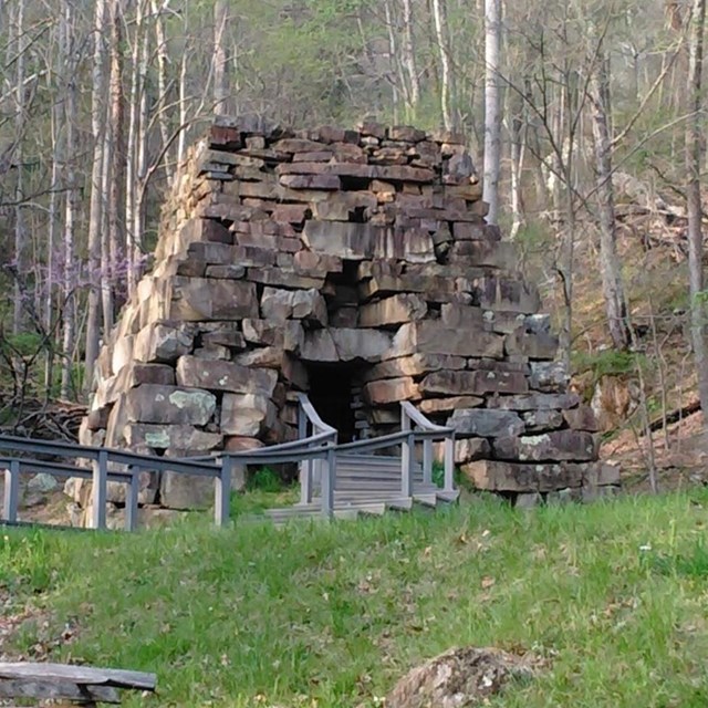 stone shaped pyramid structure with a door in the center and a walkway leading up.