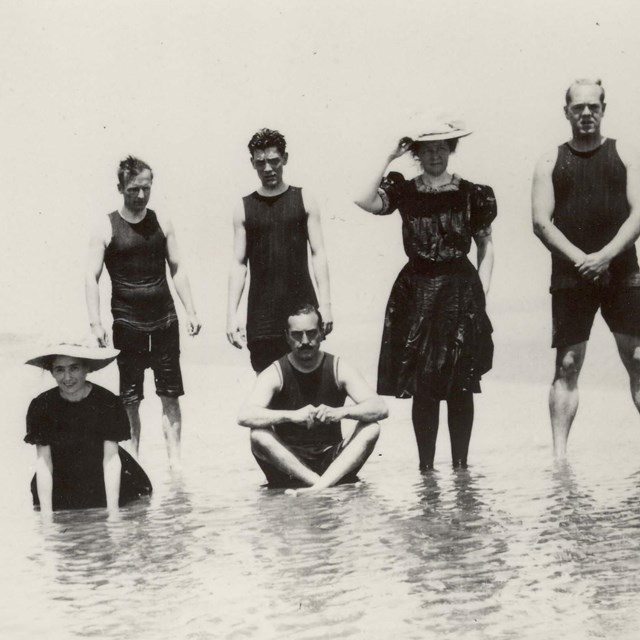 Historical photo of people in swimming costumes in water 