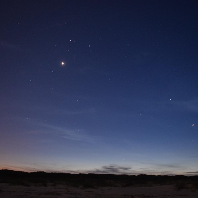 starry night sky from the beach, looking back over the dunes