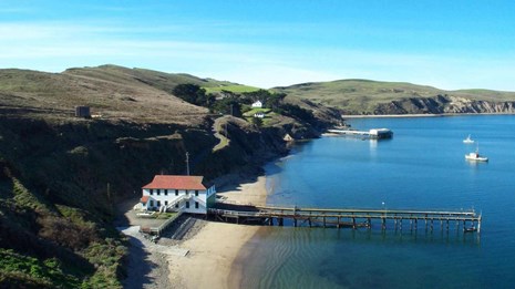 Modern view of historic Lifeboat Station with wharf extending into water from a structure onshore