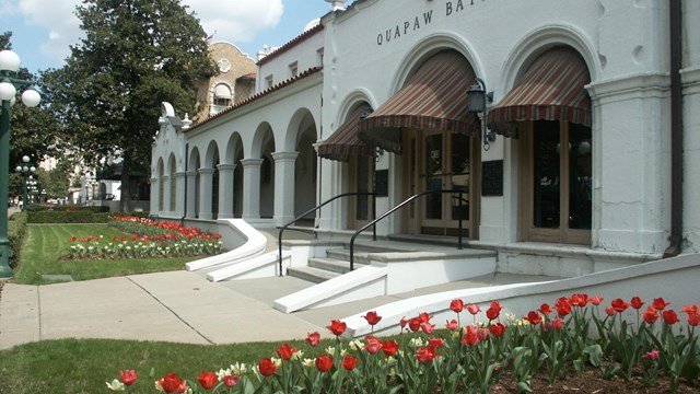 Neat tulip beds with red and pale yellow flowers adorn the yard of the Quapaw Bathhouse