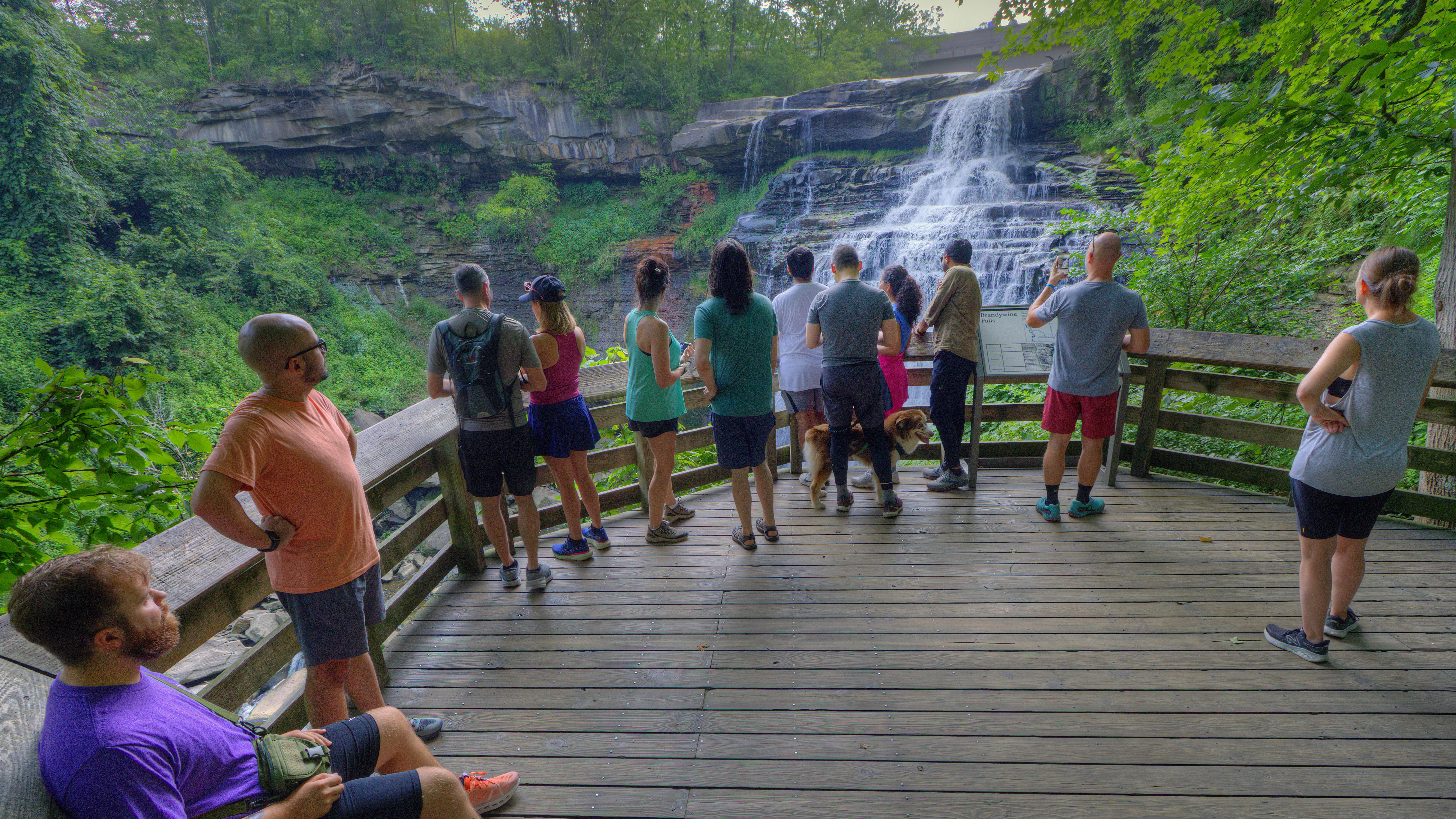 A crowd of people look at a waterfall.