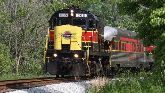 The Cuyahoga Valley Scenic Railroad train is coming around a corner.