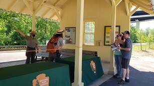 The Boston Mill Train Depot was an outdoor visitor center where staff are helping visitors.