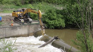 An aerial view of the excavator crew notching the Brecksville Diversion Dam from day 1 of demolition
