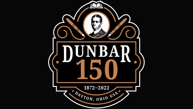 An artistic design featuring Paul Laurence Dunbar's portrait, pen, and books.