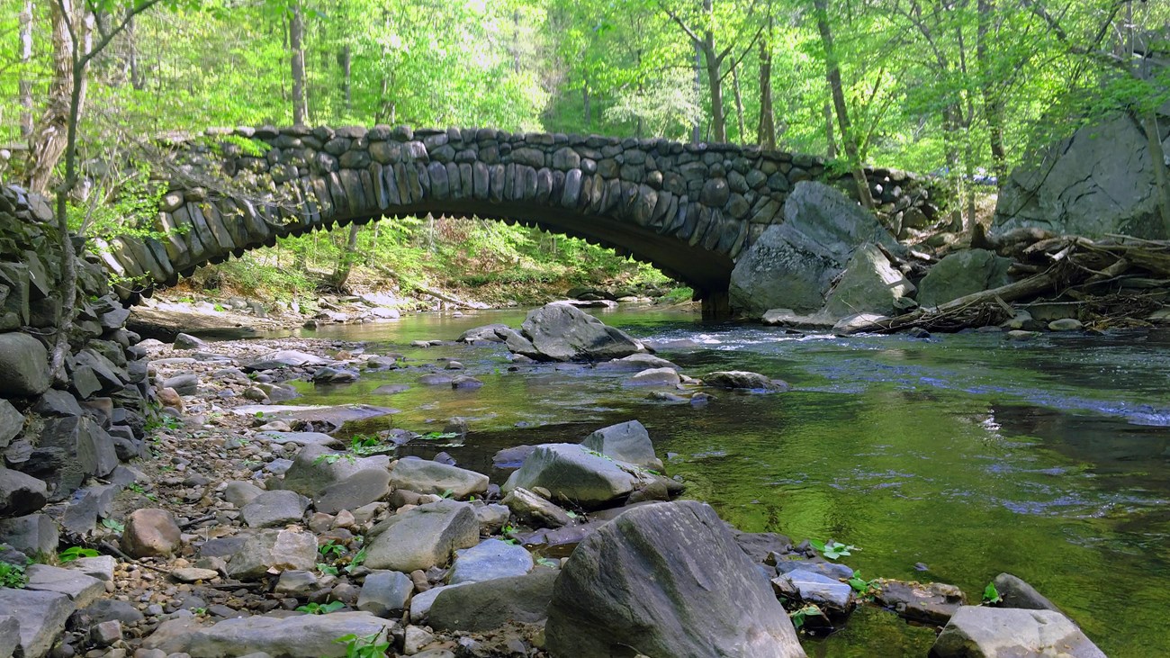 A stone bridge arches over Rock Creek