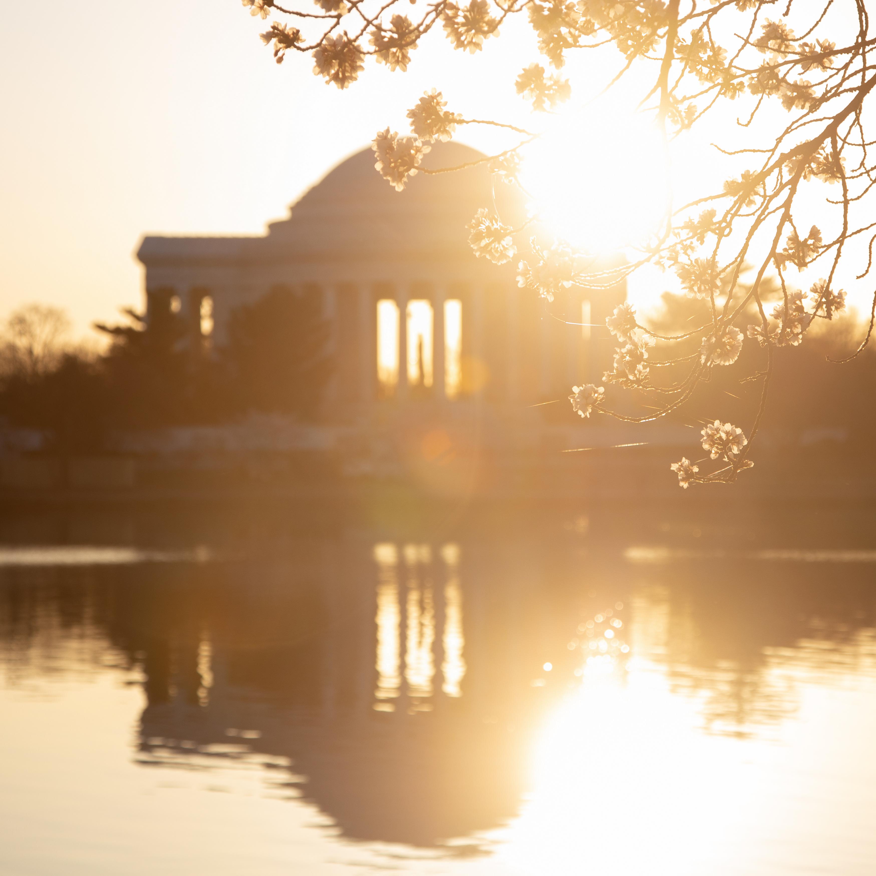 Sunrise over the Thomas Jefferson Memorial reflects off the water in the Tidal Basin.