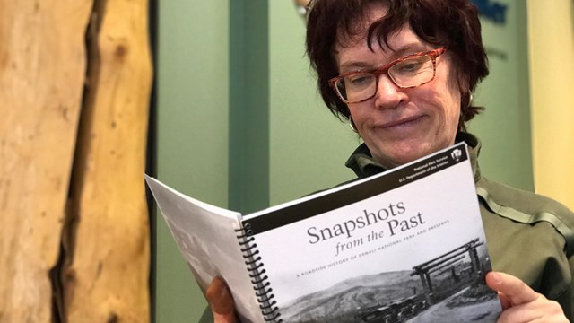 a park ranger reads a copy of "Snapshots from the Past"