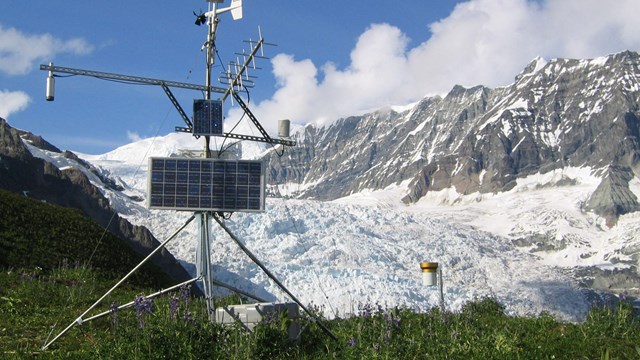 scientific equipment on a tripod in front of a glacier