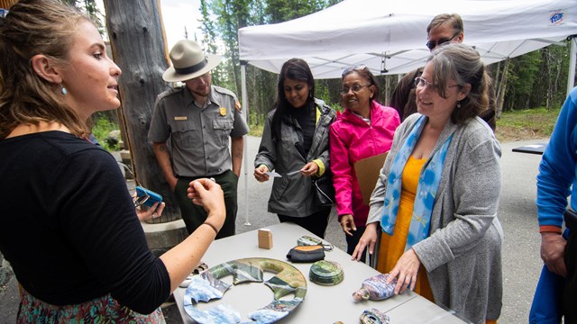 A woman shows art to a group of people