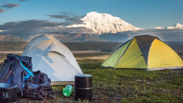 two tents looking out at a huge snowy mountain