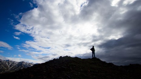a hiker walks up a mountainside