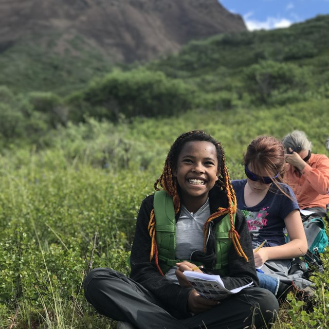 A young visitor smiles wide while working on an activity