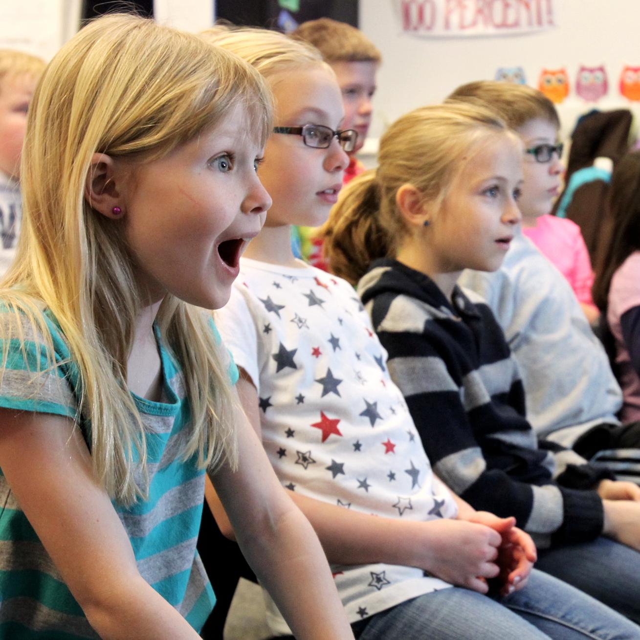 Students watch a distance learning program with excitement