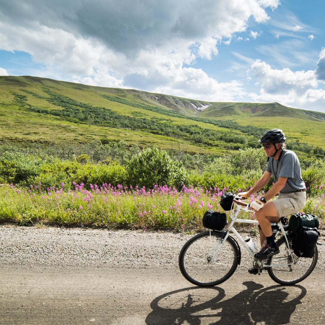man cycling on a dirt road