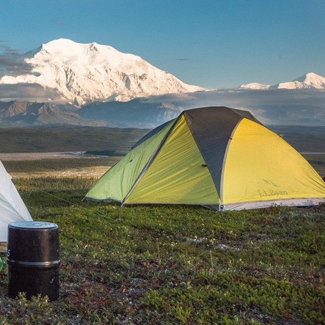 two tents looking out at a huge snowy mountain