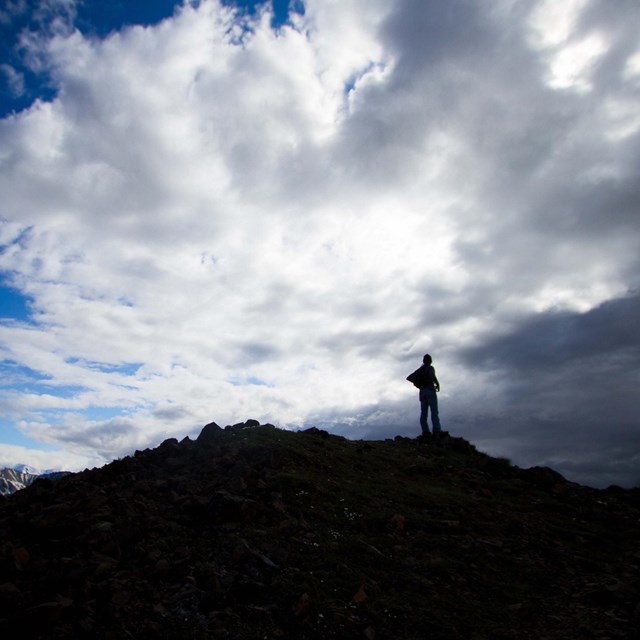 a hiker walks up a mountainside