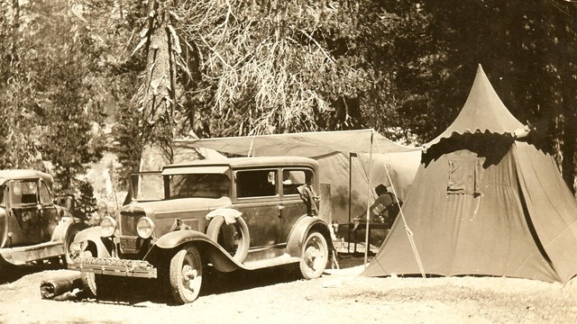 A historic photo from 1935 depicts a car camped beside a tent in the campground.