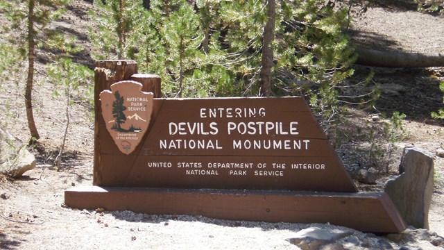 Entrance sign along the road reads "Entering Devils Postpile National Monument."