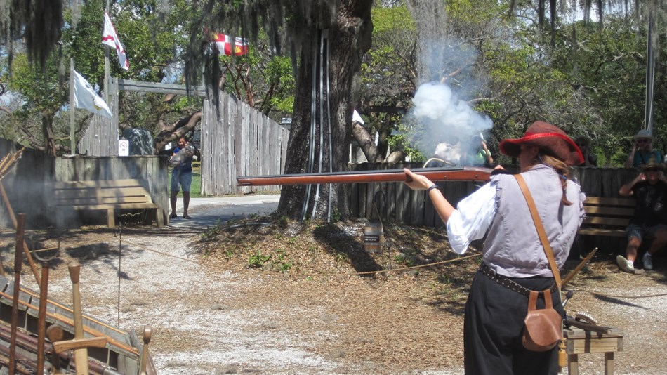 Park Ranger in Historic Costume firing a early musket in Indigenous Village