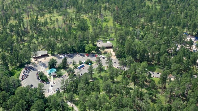 aerial view of visitor center parking lot with cars and people