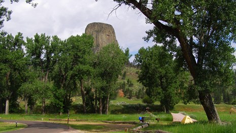 A campsite with a tent under Devils Tower