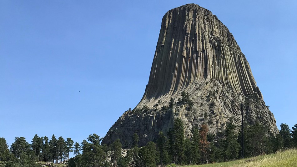 Sunny, blue sky with rock monolith in the distance 