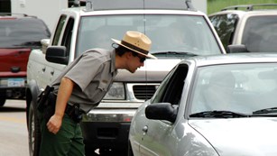 A ranger directing traffic flow at the main parking area.