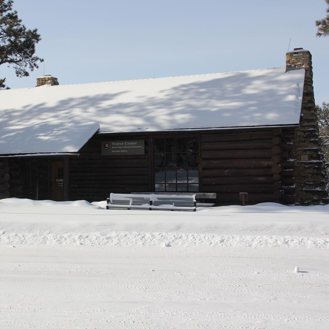 A log structure with a stone chimney.