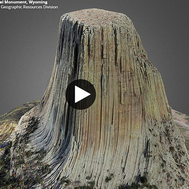 An image of a rock monolith with vertical lines covering its face.