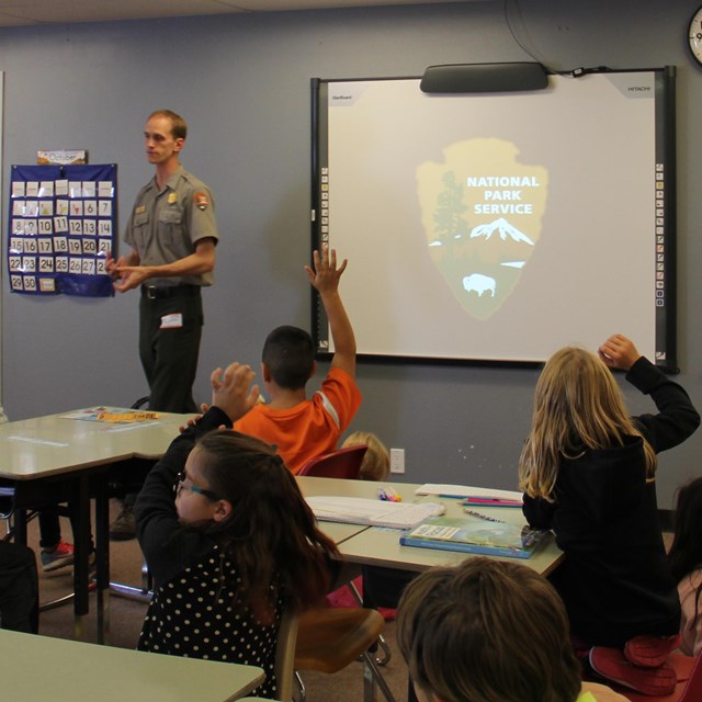 A park ranger addressing students in a classroom