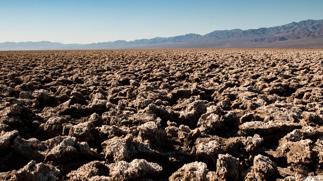 Eroded salt mounds stretch in the distance to the horizon. 