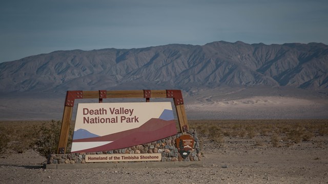 Death Valley National Park entrance sign in a desert landscape. 