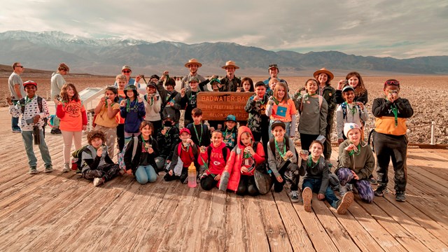 Rangers and students pose for a picture on a boardwalk.