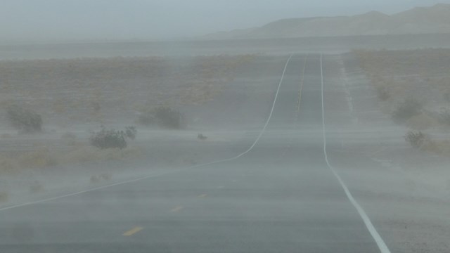 A road is obscured through sand or smog in the air
