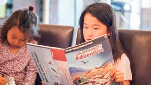 Two children holding booklets