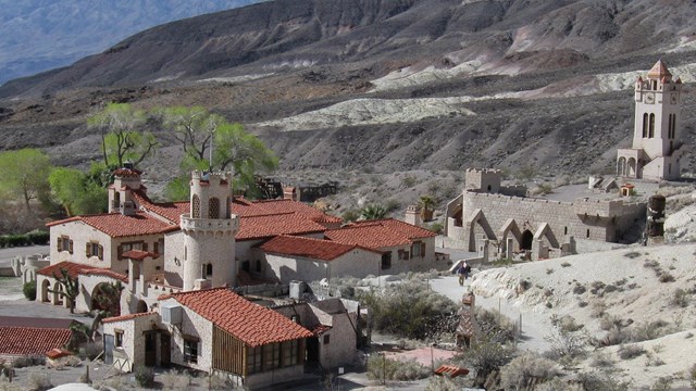 A view of spanish mission style castle set in a desert. 