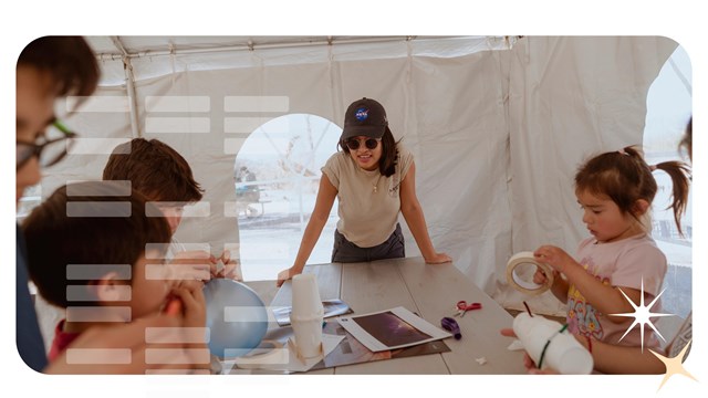 Children constructs an arts and crafts with balloons on a table.