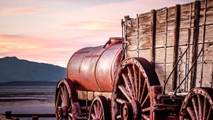 Historic wood and metal twenty mule team wagon in pink evening light. 