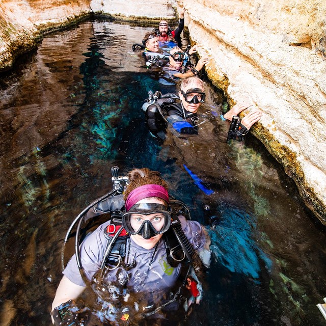Divers pose for a picture while in the water of Devils Hole for the recent survey.
