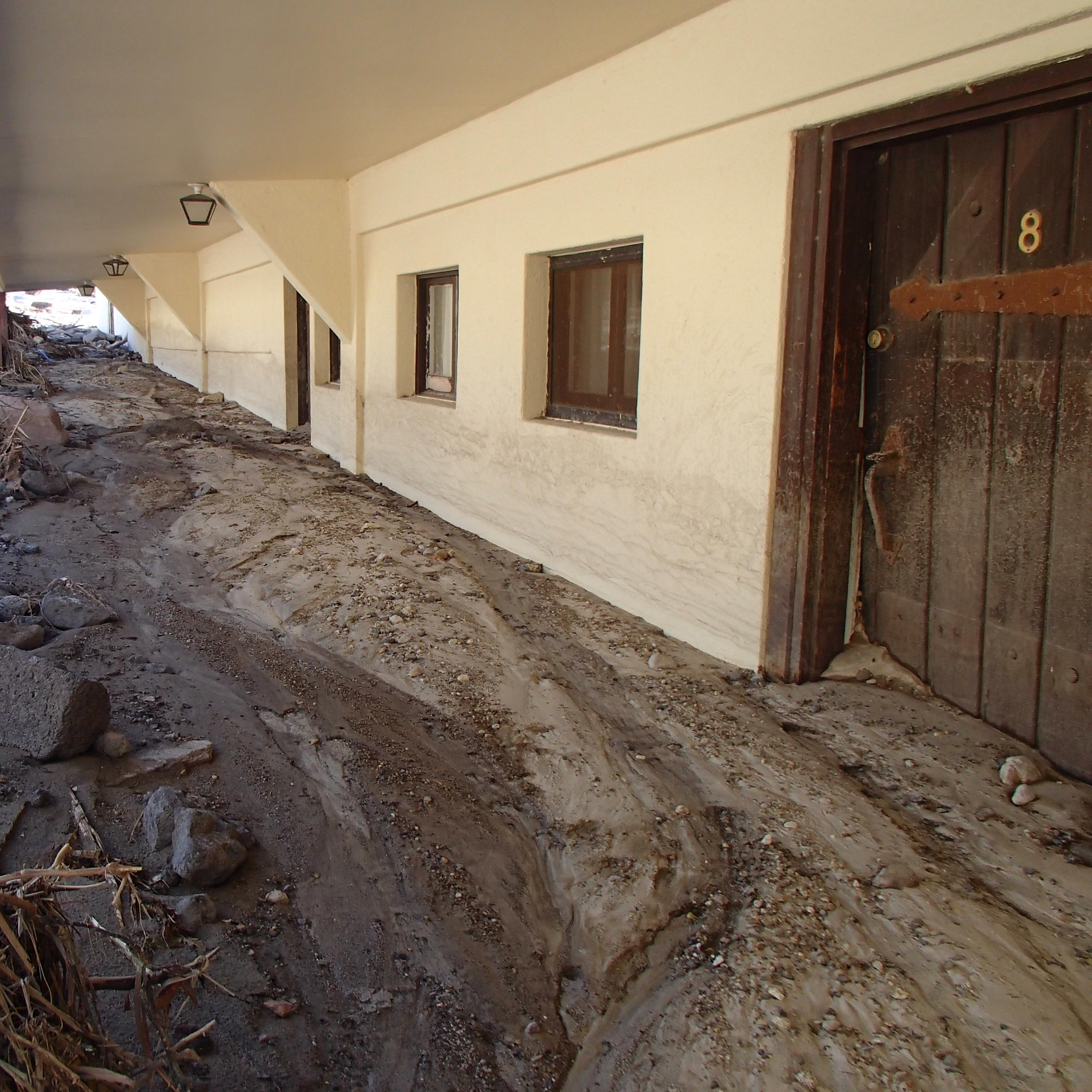 Mud halfway up white building walls.