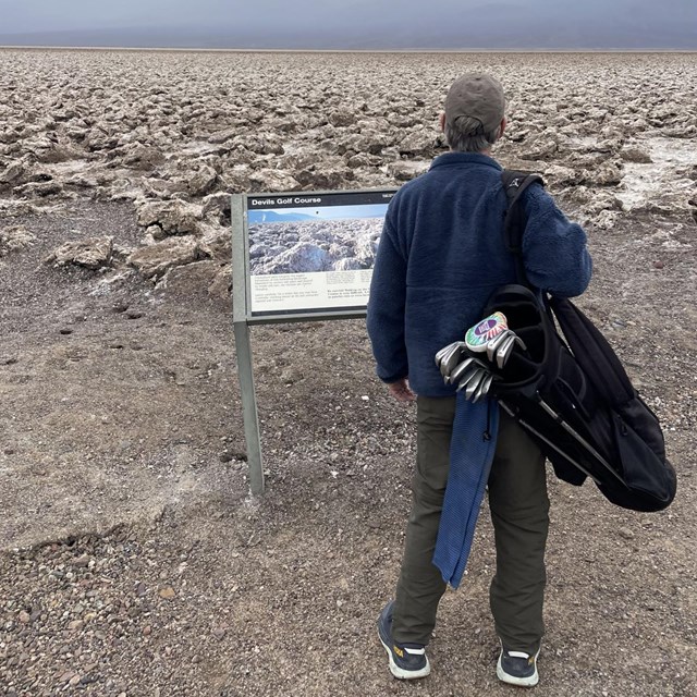 A visitor gazes out at Devil's Golf Course, a jagged salt flat