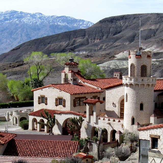 A sandy colored historic building, with red roof tiles, known as Scotty's Castle.