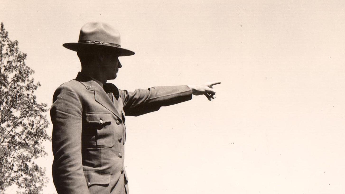 Historic image of man in ranger uniform pointing.